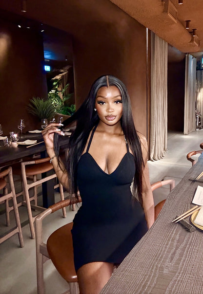 Woman in a black dress sitting at a table in a restaurant setting