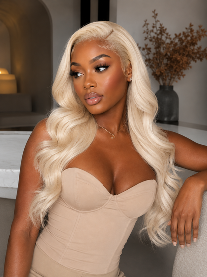 Woman with long blonde hair wearing a beige strapless top in an indoor setting.