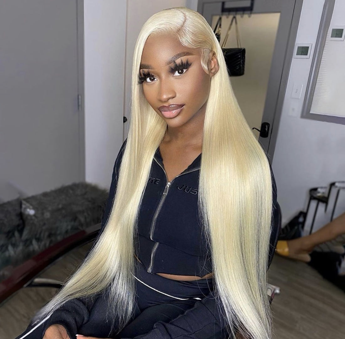 Woman with long blonde hair in a room with a mirror and door.